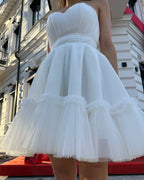 Rochie de ocazie albă scurtă cu corset și fustă evazată.