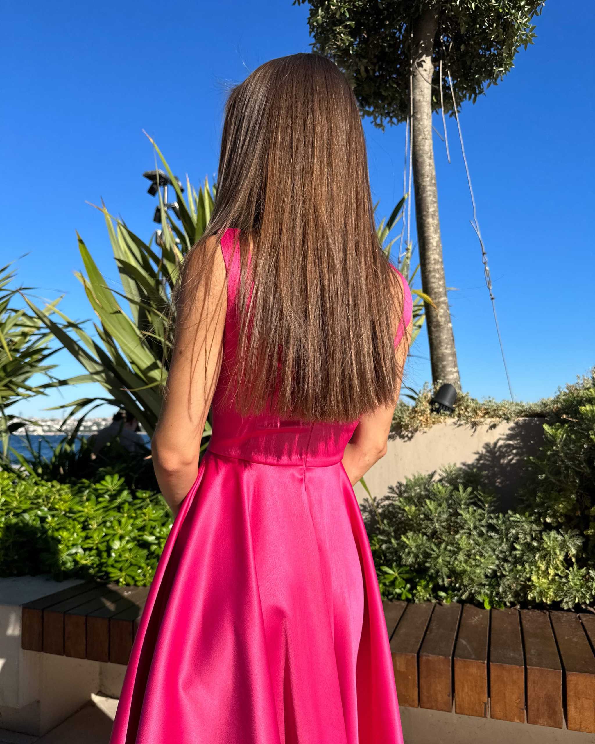 rochie eleganta roz decoltata fara maneci in gradina sub soare claras