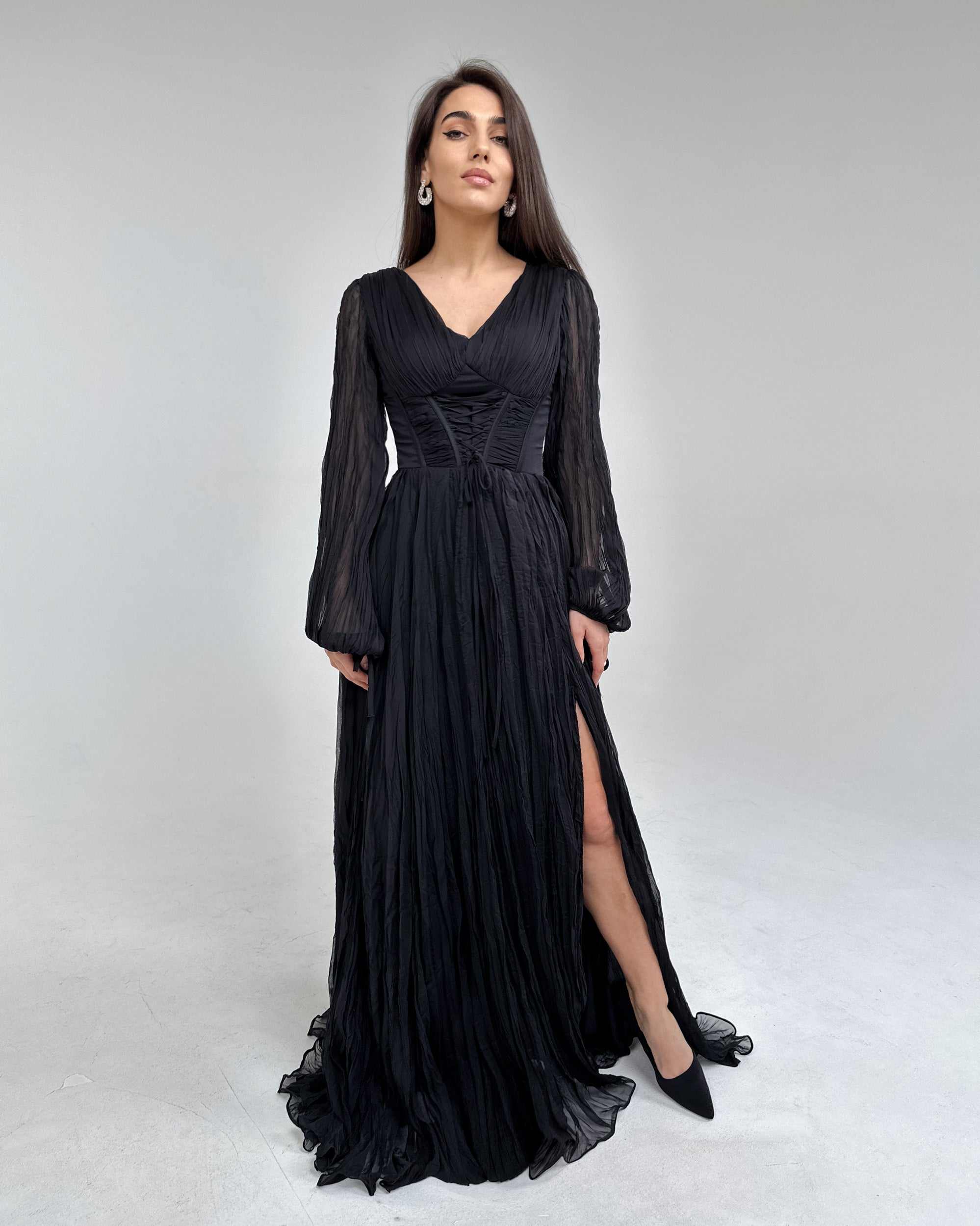 Rochie lunga neagră cu mâneci lungi și șliț elegant.