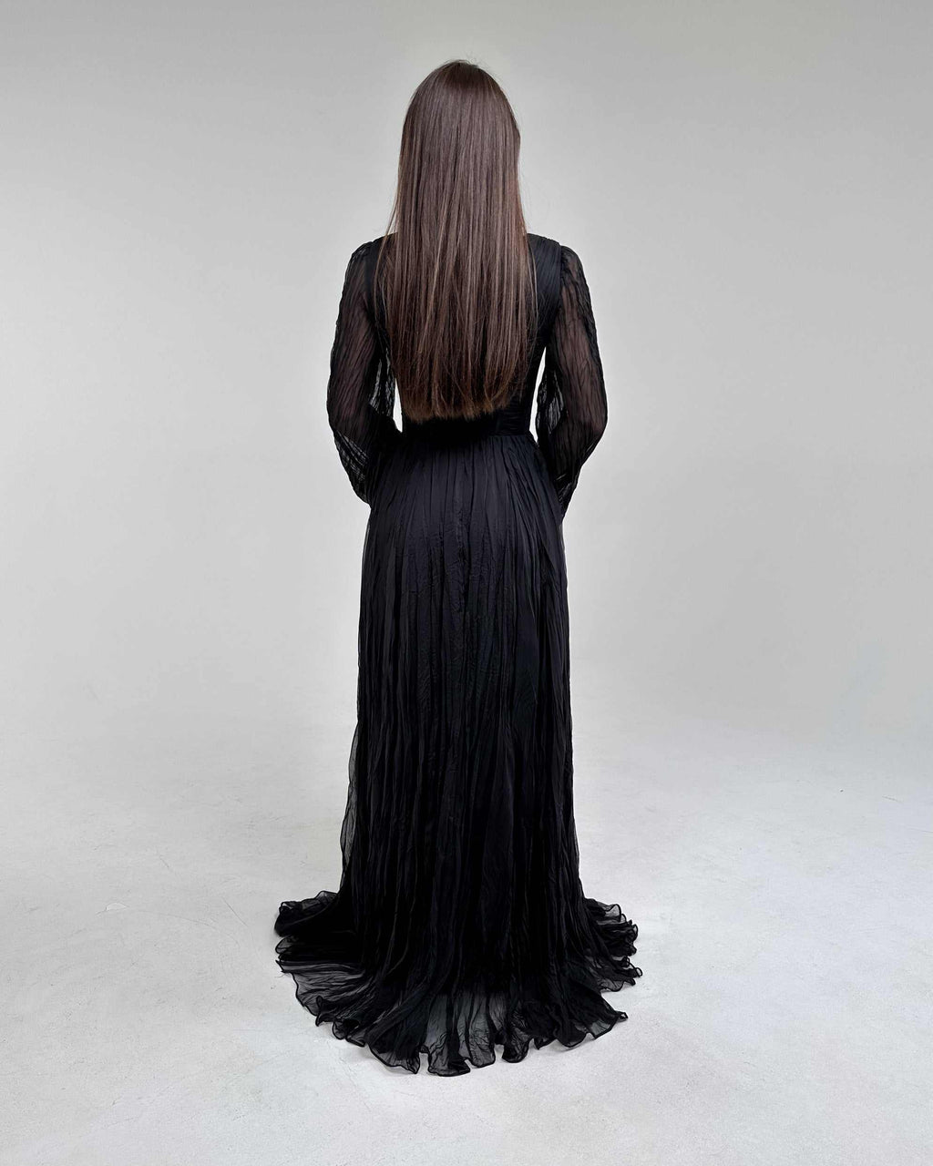 Rochie lunga neagră cu mâneci lungi și șliț, vedere din spate.