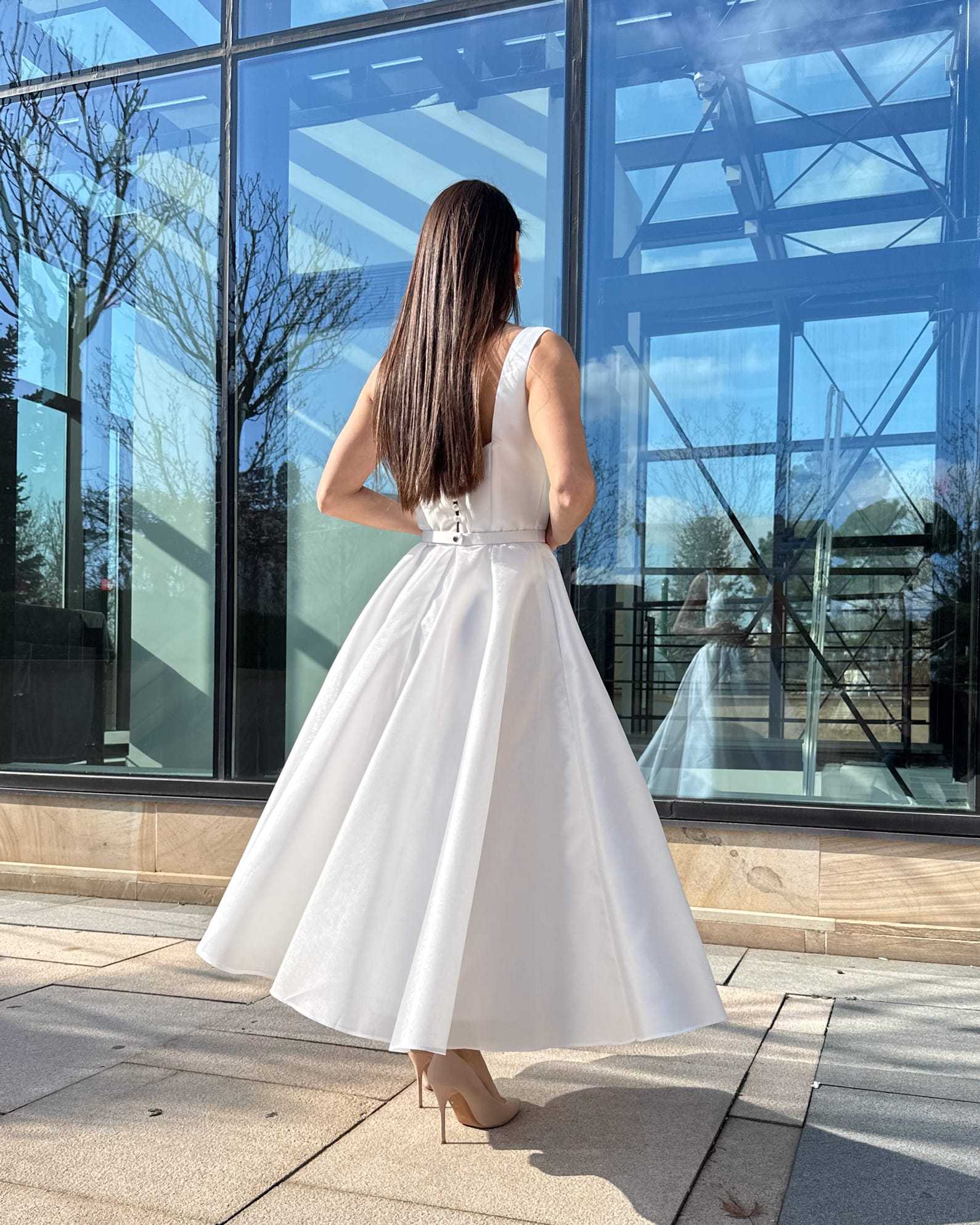 Rochie de mireasa midi albă cu buzunare și centură delicată, design modern și elegant.