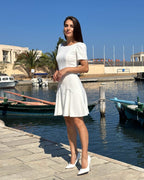 Rochie albă scurtă cloș cu mâneci, ideală pentru un look feminin și elegant, din stofă semielastică.