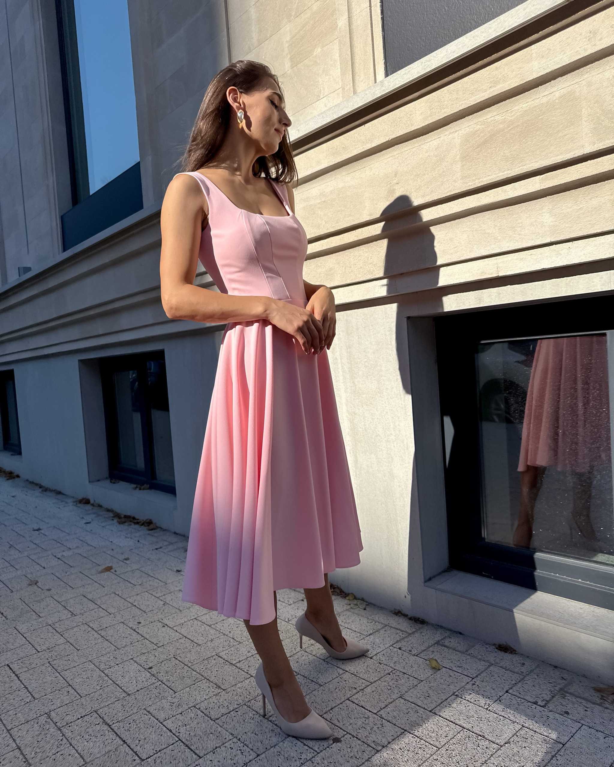 Rochie roz eleganta roz midi cu decolteu și sistem de închidere laterală.