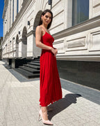 Rochie rosie midi cu bretele subțiri și decupaj frontal elegant, ideală pentru evenimente speciale.