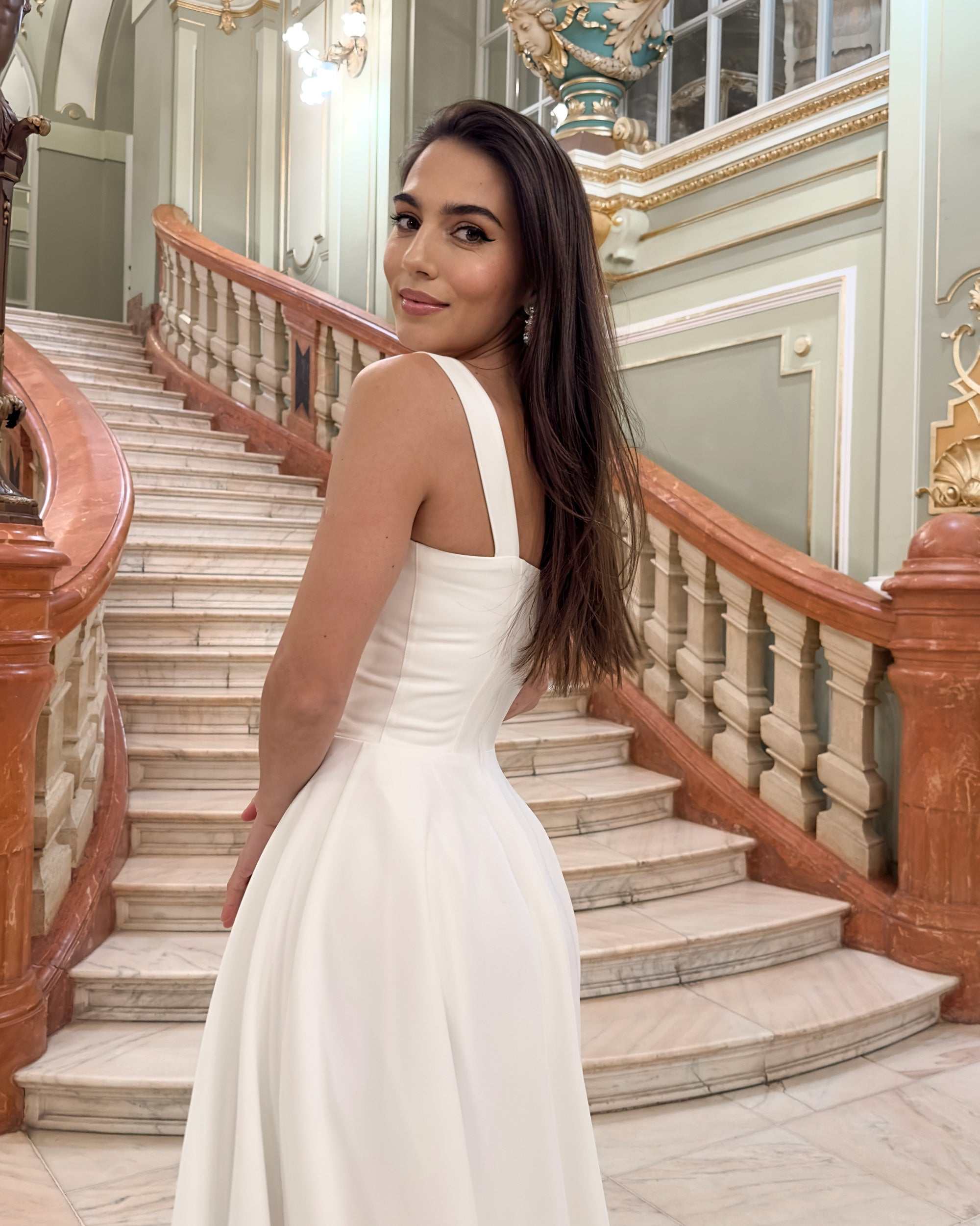 Rochie elegantă de ocazie albă, croială A-line, bretele late, pe scări interioare luxoase