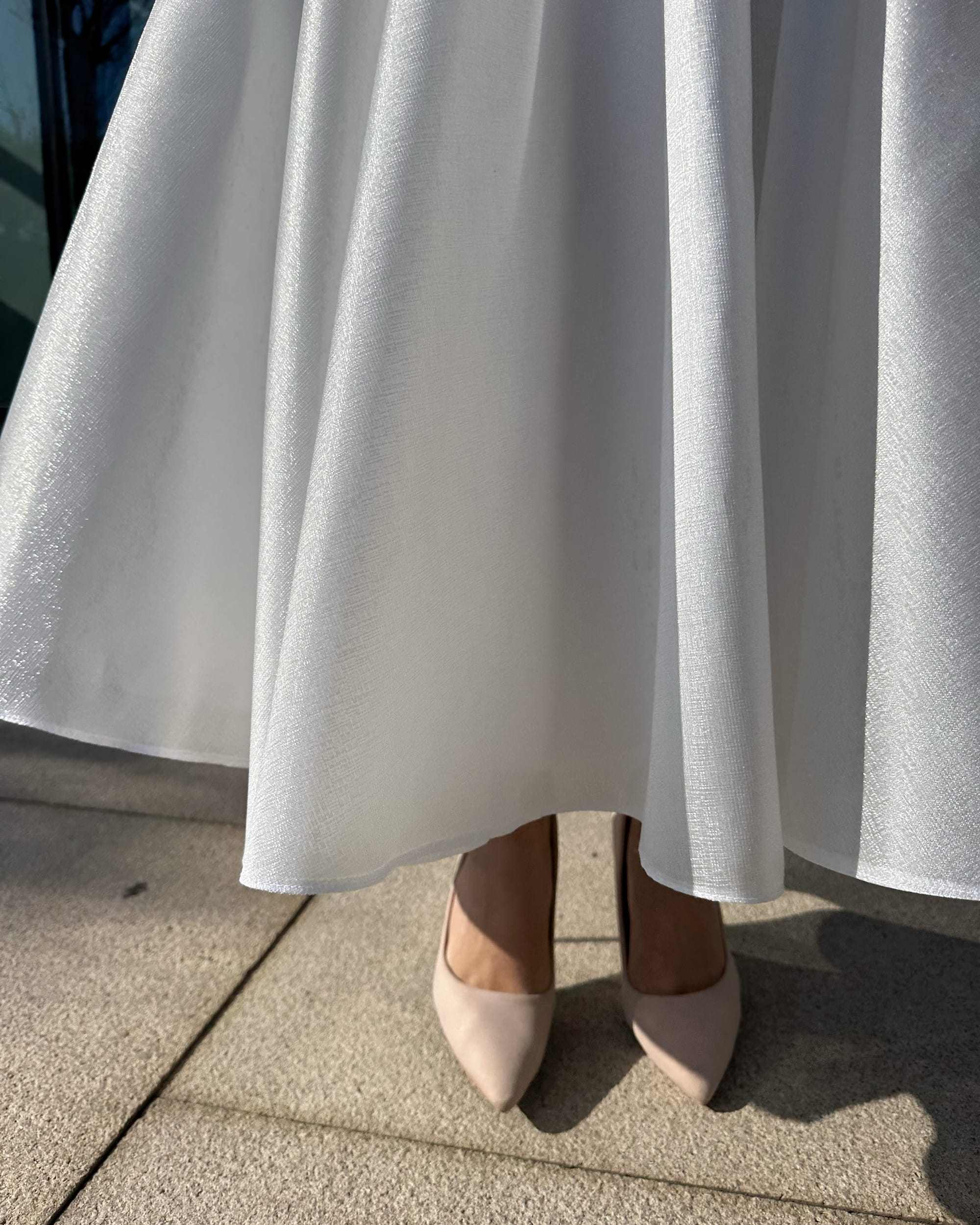 Rochie de mireasa midi albă, elegantă, cu buzunare și detalii moderne.