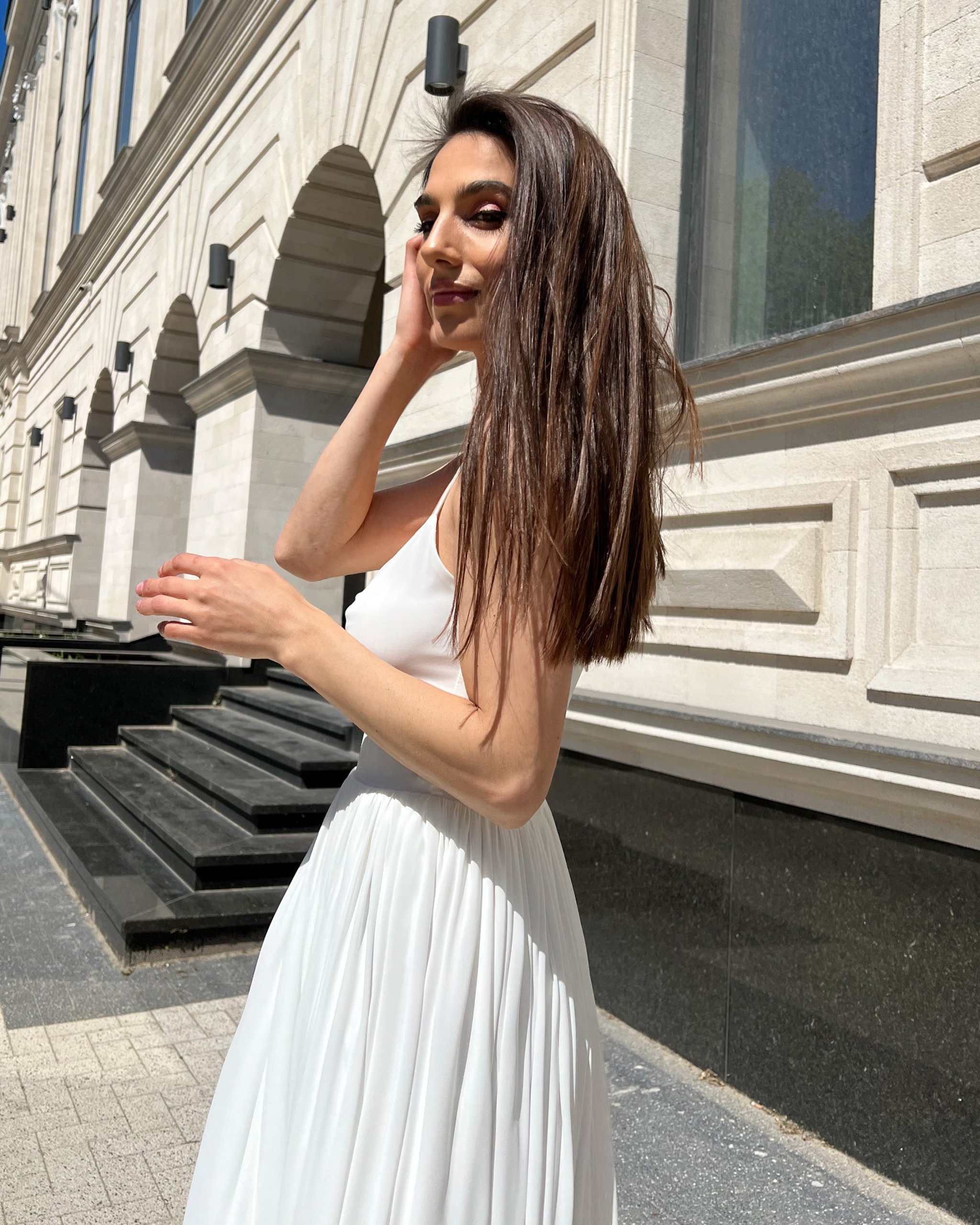 Rochie alba elegantă cu bretele și slit, centură în talie, fermoar la spate.