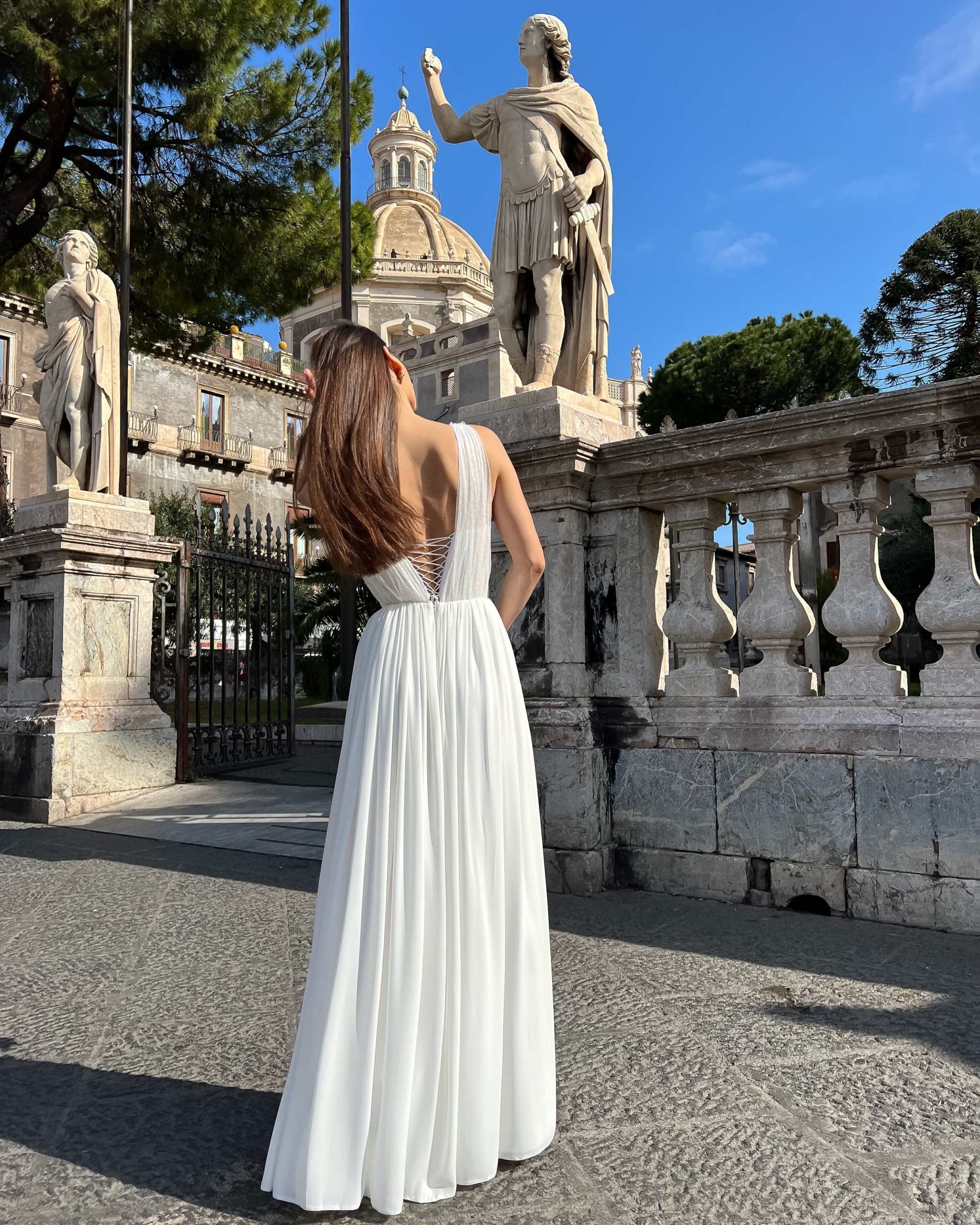 Rochie cununie albă lungă cu corset reglabil și dantelă fină într-un cadru elegant.