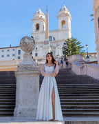 Rochie de mireasa albă lungă din satin elegantă cu șliț și mâneci transparente.