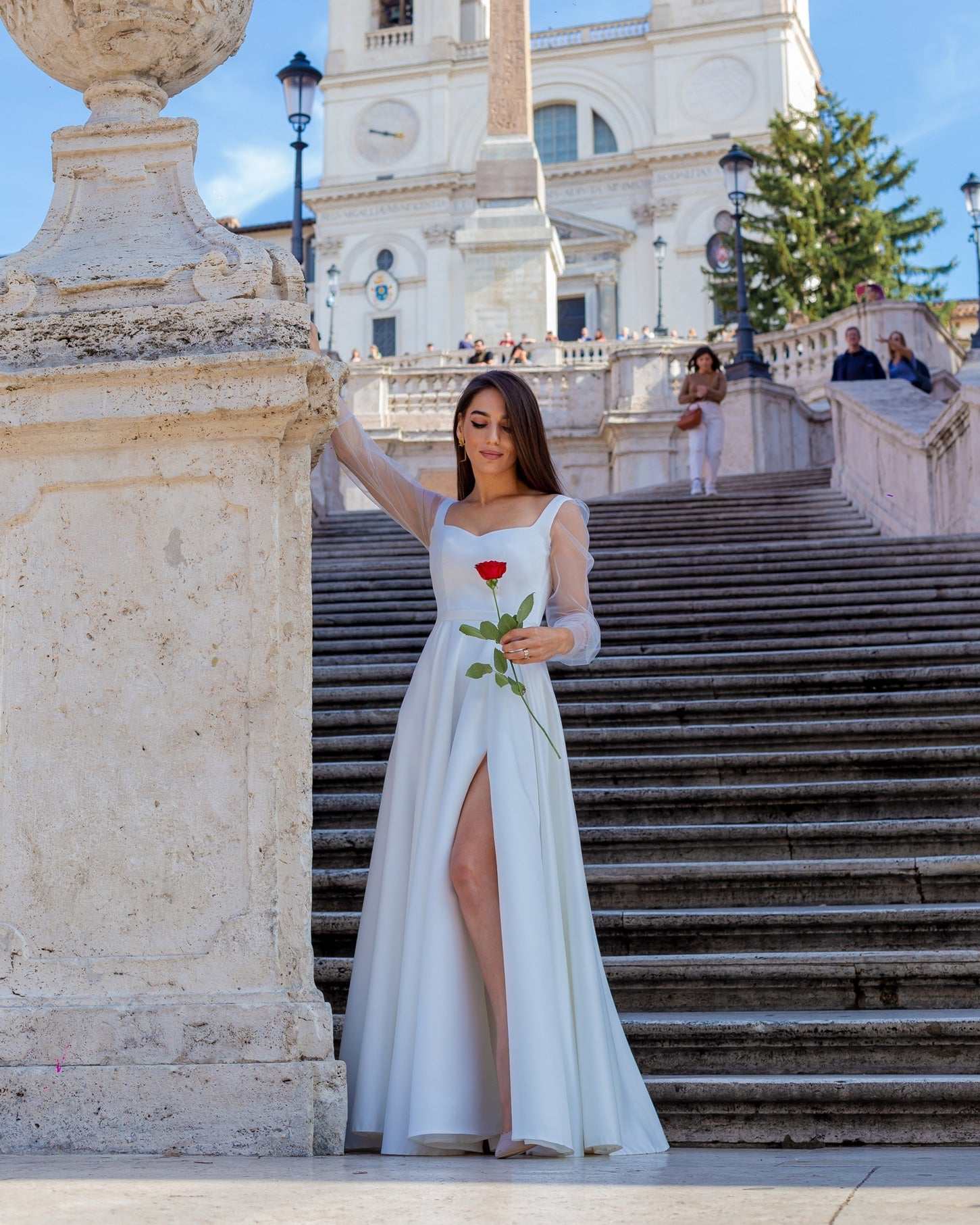 Rochie de mireasa albă lungă din satin elegantă cu șliț și mâneci transparente.