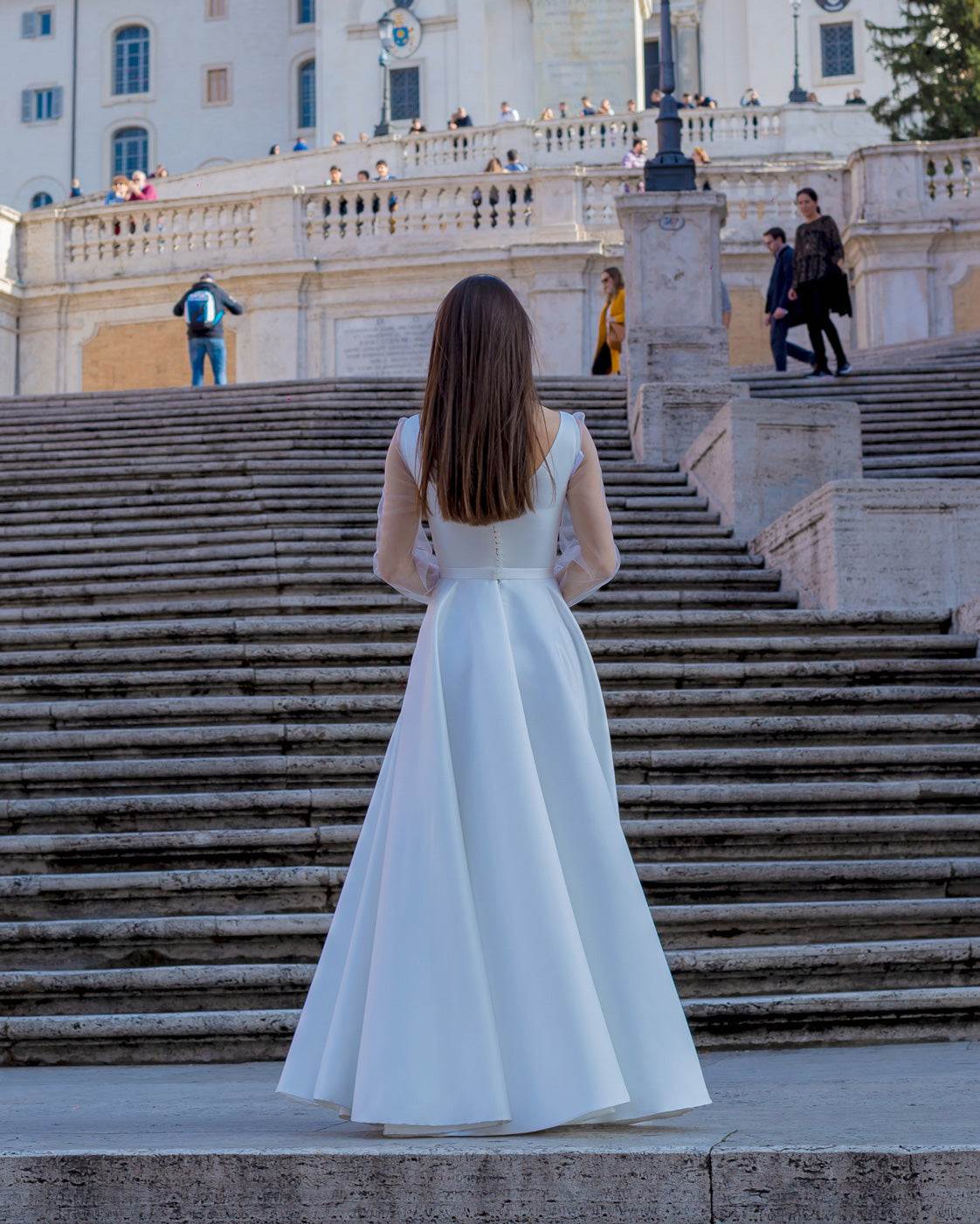 Rochie de mireasa albă lungă din satin elegantă cu șliț și mâneci transparente.