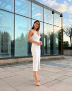 Rochie eleganta alba cu captuseală, croială ajustată și tăietură centrală, purtată de model.