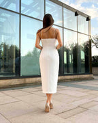 Rochie eleganta alba cu căptușeală, tăietură centrală și detalii decorative, vedere din spate.