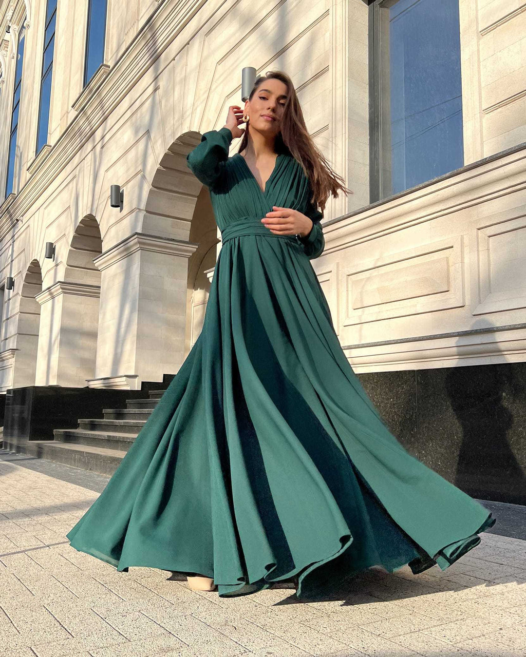 Rochie elegantă de seară lungă din voal verde, decolteu în V și pliuri, cu mâneci lungi și nasturi, ideală pentru evenimente formale.