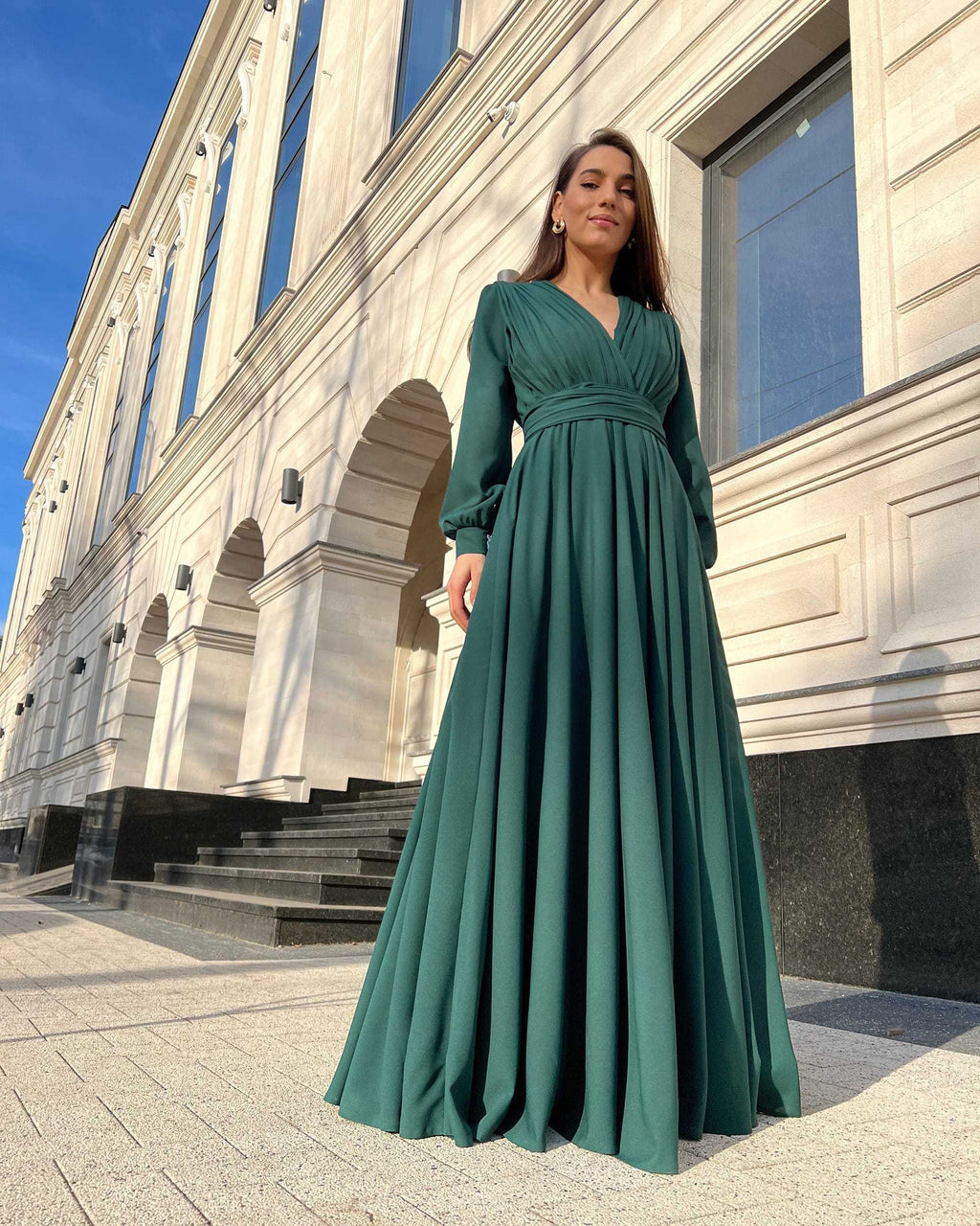 Rochie elegantă de seară lungă din voal verde, cu decolteu în V și mâneci lungi, perfectă pentru evenimente formale.