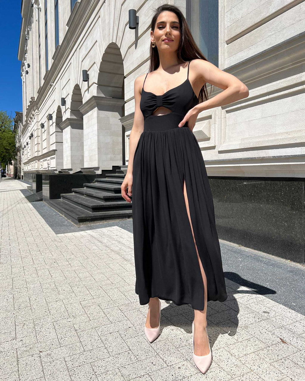 Rochie neagra cu slit și bretele, lungă, cu fermoar la spate.